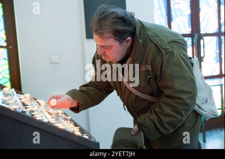 Credente religioso cattolico che brucia candele. Un credente religioso cattolico che brucia candele all'interno della cattedrale di San Giuseppe di Sofian. Sofia, Bulgaria. MRYES Sofia Ulitsa Knyaz Boris i 125 Sofia Bulgaria Copyright: XGuidoxKoppesxPhotox Foto Stock