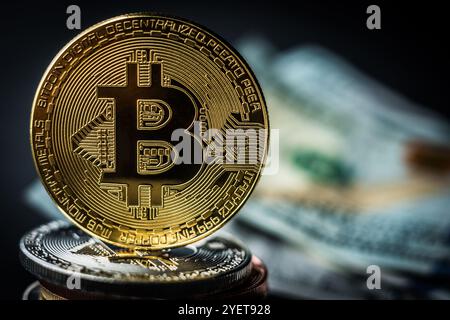 Bitcoin dorato su una pila di monete metalliche. Bitcoin fisico con sfondo in dollari. Concetto di trading di criptovalute e blockchain Foto Stock