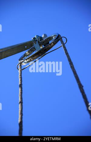 Puleggia rotonda con fune per il sollevamento di un carico in cantiere Foto Stock