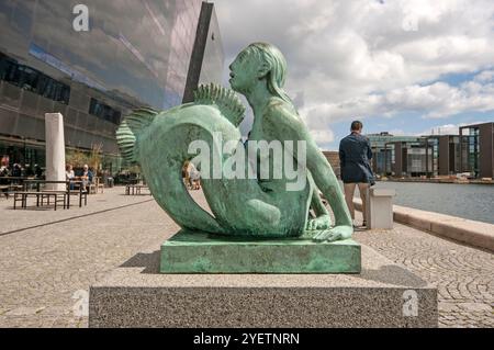 Statua in bronzo della Sirenetta di Anne Marie Carl Nielsen (1863-1945) all'esterno del diamante nero, estensione alla Biblioteca reale danese, Copenaghen, Danimarca Foto Stock