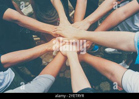 Concetto di lavoro di squadra. Gruppo di persone che si occupano di diversità approfondiscono il successo del team salutando la potenza del team tag. Gruppo di persone multietniche che lavorano insieme. Foto Stock