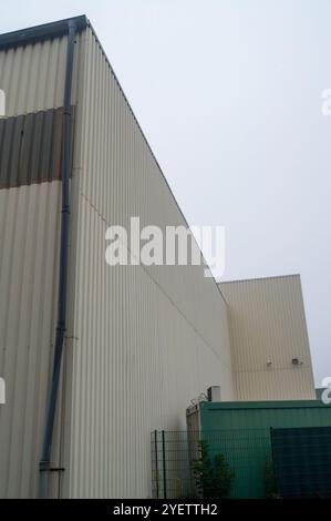 Rivestimento in metallo su un edificio industriale con telecamera di sicurezza e downspout, che offre un senso di sicurezza e funzionalità Foto Stock