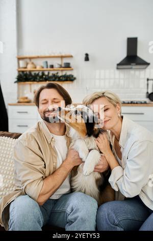 Una coppia amorevole si abbraccia l'un l'altro e il suo cane mentre si gode un momento sereno in casa. Foto Stock