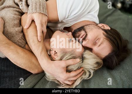 Un momento tenero condiviso tra i partner mentre si rilassano insieme nel loro spazio accogliente. Foto Stock