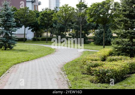 Sentiero circondato da alberi e arbusti ornamentali a Kiev, Europa. Luogo ricreativo nel parco cittadino Foto Stock