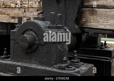 Parti massicce di macchine industriali nere d'epoca, foto ravvicinata con messa a fuoco selettiva, sfondo astratto per l'industria pesante Foto Stock