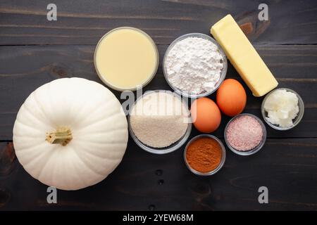 Ingredienti per torta di zucca bianca su un tavolo di legno: Zucca bianca con farina, zucchero, spezie di zucca e altri ingredienti per torta di zucca Foto Stock