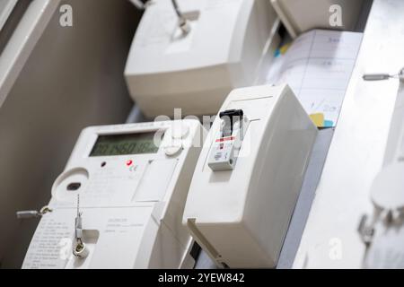 Vista dettagliata di un moderno misuratore elettrico digitale con interruttori e cablaggio. Questa immagine mette in evidenza precisione e tecnologia nella gestione dell'energia, idea Foto Stock