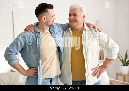 Uomo maturo con suo figlio che abbraccia a casa Foto Stock