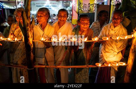 Le donne anziane di Pramod Talukdar Memorial Old Age Home illuminano le lampade a olio di Diya mentre celebrano Diwali, a Guwahati, India, il 1° novembre 2024. Diwali, noto anche come Festival delle luci, è uno dei festival indù più celebrati, simboleggiando la vittoria della luce sulle tenebre e il bene sul male. Crediti: David Talukdar/Alamy Live News Foto Stock