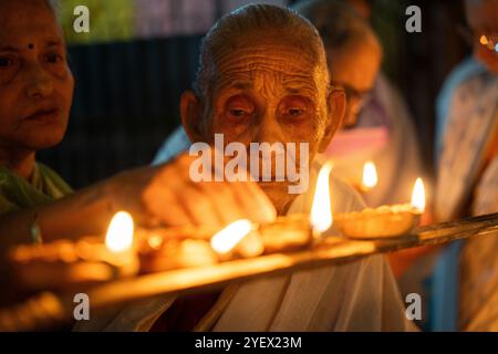 Le donne anziane di Pramod Talukdar Memorial Old Age Home illuminano le lampade a olio di Diya mentre celebrano Diwali, a Guwahati, India, il 1° novembre 2024. Diwali, noto anche come Festival delle luci, è uno dei festival indù più celebrati, simboleggiando la vittoria della luce sulle tenebre e il bene sul male. Crediti: David Talukdar/Alamy Live News Foto Stock