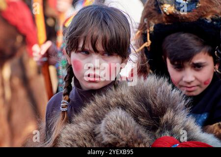 Comănești, Romania, dicembre 2023: L'uomo locale vestito di pelliccia di orso, tradizioni rumene, partecipa alla danza dell'orso al Comănești Traditions Fest Foto Stock