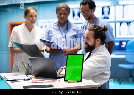 Diversi team di specialisti che esaminano le scansioni di test radiografici con schermo isolato in una riunione, esaminando i risultati dei raggi X in un centro di trattamento. Personale professionale che garantisce la prevenzione delle malattie. Foto Stock