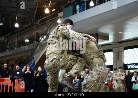 I Royal Marines Commandos tengono una dimostrazione fisica alla stazione di Waterloo a Londra il 1 novembre 2024 a sostegno della Royal British Legion Foto Stock