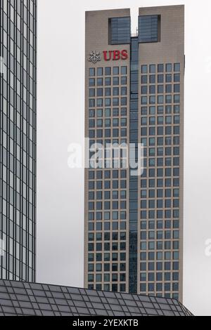 Francoforte Germania - 26 ottobre 2024: L'alta torre di uffici UBS, con la sua facciata distinta, sorge nello skyline della città, circondata da altri edifici moderni Foto Stock