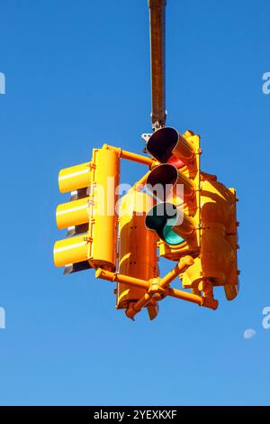 semafori gialli contro il cielo azzurro sospeso sopra l'incrocio a 4 vie a manhattan, new york, usa Foto Stock