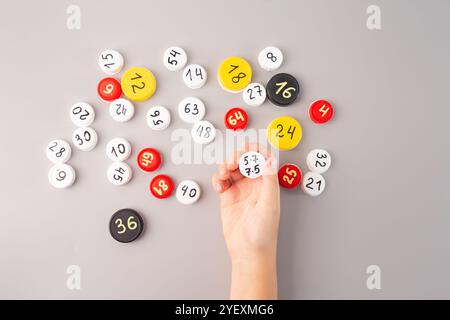 tappi per bottiglie in plastica con numeri scritti a mano e dati moltiplicati su sfondo grigio attività didattica di matematica per bambini che imparano a fare pratica di calcolo Foto Stock