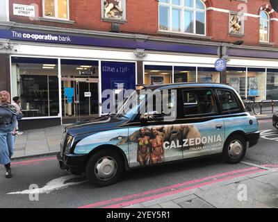 Taxi nero con la pubblicità di Calzedonia sul lato di White Lion Street, Angel Islington London Foto Stock