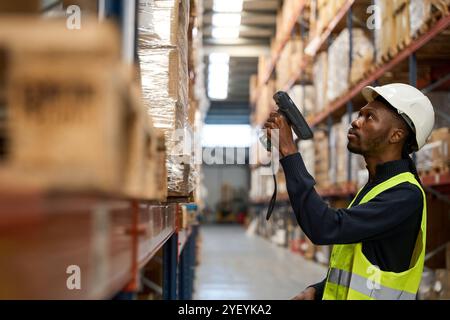 Addetto al magazzino che controlla l'inventario con lo scanner di codici a barre Foto Stock