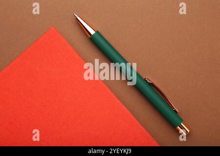 Notebook e penna su sfondo marrone, vista dall'alto Foto Stock
