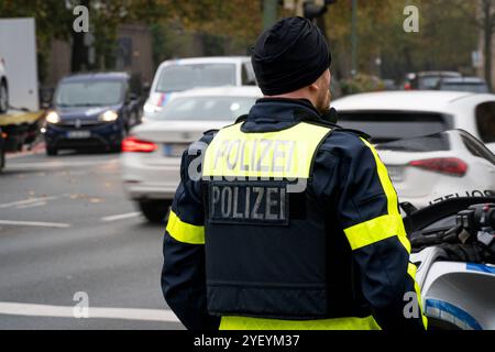 Landkreis Osnabrück, Deutschland 01. Novembre 2024: IM Bild: Ein Beamter der Polizei, steht mit einer Polizeiweste an einer befahrenen Straße. Niedersachsen *** Distretto di Osnabrück, Germania 01 novembre 2024 nella foto Un agente di polizia si trova con un giubbotto di polizia su una strada trafficata bassa Sassonia Copyright: XFotostandx/xKippx Foto Stock