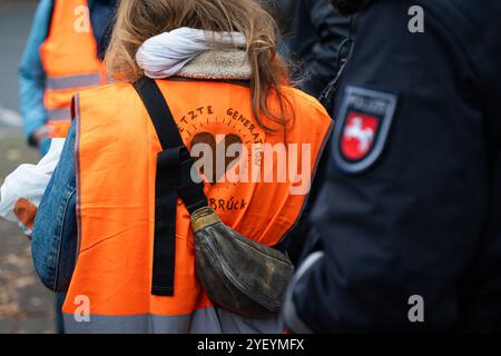 Landkreis Osnabrück, Deutschland 01. Novembre 2024: IM Bild: Die Letzte Generation ist ein Zusammenschluss und seit Ende 2023 eingetragene Marke von Klimaaktivisten. Hier die letzte Generation bei einer Aktion a Osnabrück. Neben den Aktivisten steht ein Polizist. Niedersachsen *** Distretto di Osnabrück, Germania 01 novembre 2024 nella foto The Last Generation è un'associazione e marchio registrato di attivisti per il clima dalla fine del 2023 qui The Last Generation at an action in Osnabrück accanto agli attivisti si trova un ufficiale di polizia della bassa Sassonia Copyright: XFotostandx/xKippx Foto Stock