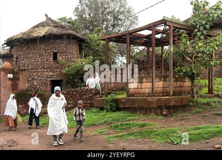 Abitanti del villaggio nella loro tradizionale casa rotonda a due piani con scale interne e tetti di paglia, Lalibela, Etiopia Foto Stock