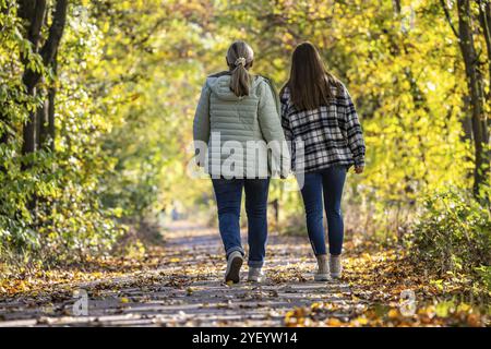 Una passeggiata attraverso una colorata foresta autunnale. Due giovani donne su un percorso circolare sulle rive del Neckar a Stoccarda, Baden-Wuerttemberg, Germania, EUR Foto Stock
