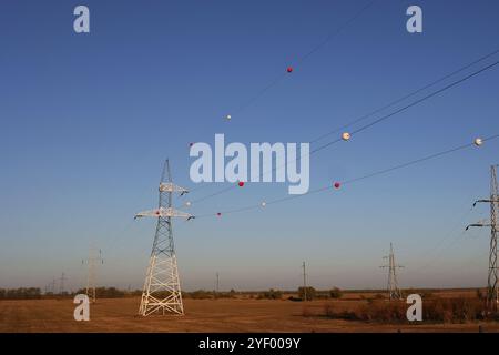 Le sfere di plastica colorate appese su cavi elettrici sospesi sono chiamate sfere di marcatura aerea e sono installate lungo la lunghezza dei fili a. Foto Stock