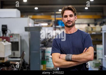 Ingegnere donna che opera macchinari nella fabbrica di parti meccaniche personalizzate in tessuto metallurgico Foto Stock