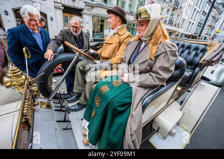 Londra, Regno Unito. 2 novembre 2024. Una coppia spiega i comandi di una Mercedes-Simplex, 1904 - sono 120 anni di formazione sinc ehte del Womens Automobile Club, quindi sono molte donne piloti in abiti d'epoca - lo spettacolo automobilistico di St James sul Pall Mall, una celebrazione del motociclismo attraverso i secoli e nel futuro. Le auto in mostra spaziano dai pionieristici vincitori del Gran Premio, risalenti agli albori degli sport motoristici, fino alle supercar più recenti, che mettono in mostra tecnologie rivoluzionarie. Organizzato dal Royal Automobile Club. Si svolge alla vigilia del RM Sotheby's London per Brighton Veteran Car R. Foto Stock