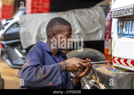 Giovane meccanico impiegato in un garage a Bukavu, RDC. Foto Stock