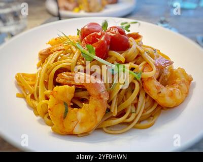 Primo piano di un piatto di linguine con gamberi, zuppa di aragosta e pomodori Foto Stock