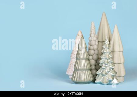 Alberi di Natale in ceramica verde chiaro di diversa forma sul lato dello sfondo blu con spazio per le copie Foto Stock