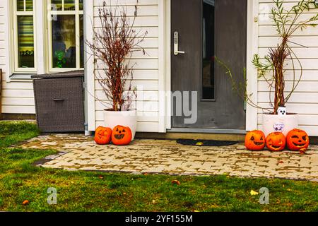 Veranda di Halloween decorata con zucche intagliate e piante in vaso autunnali, creando un'atmosfera festosa. Foto Stock