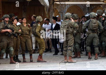 I coloni israeliani sono scortati da soldati israeliani durante un tour del mercato nella parte palestinese della città vecchia i coloni israeliani sono scortati da soldati israeliani durante un tour del mercato nella parte palestinese della città vecchia di Hebron nella Cisgiordania occupata il 2 novembre 2024. Foto di Mamoun Wazwaz apaimages Hebron Cisgiordania territorio palestinese 021124 Hebron MW 0022 Copyright: XapaimagesxMamounxWazwazxxapaimagesx Foto Stock