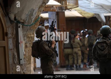 I coloni israeliani sono scortati da soldati israeliani durante un tour del mercato nella parte palestinese della città vecchia i coloni israeliani sono scortati da soldati israeliani durante un tour del mercato nella parte palestinese della città vecchia di Hebron nella Cisgiordania occupata il 2 novembre 2024. Foto di Mamoun Wazwaz apaimages Hebron Cisgiordania territorio palestinese 021124 Hebron MW 0021 Copyright: XapaimagesxMamounxWazwazxxapaimagesx Foto Stock