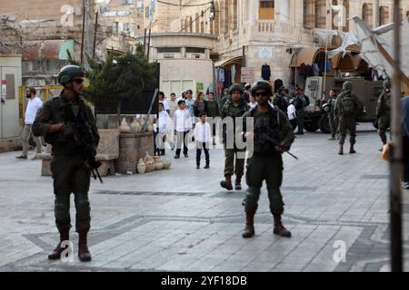 I coloni israeliani sono scortati da soldati israeliani durante un tour del mercato nella parte palestinese della città vecchia i coloni israeliani sono scortati da soldati israeliani durante un tour del mercato nella parte palestinese della città vecchia di Hebron nella Cisgiordania occupata il 2 novembre 2024. Foto di Mamoun Wazwaz apaimages Hebron Cisgiordania territorio palestinese 021124 Hebron MW 0042 Copyright: XapaimagesxMamounxWazwazxxapaimagesx Foto Stock