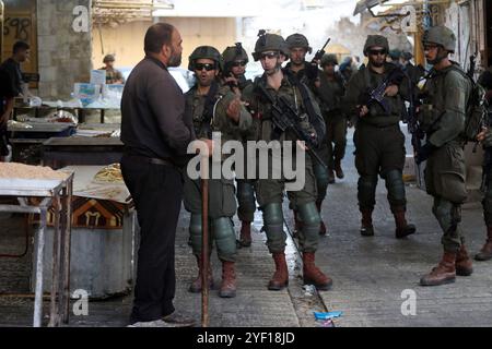 I coloni israeliani sono scortati da soldati israeliani durante un tour del mercato nella parte palestinese della città vecchia i coloni israeliani sono scortati da soldati israeliani durante un tour del mercato nella parte palestinese della città vecchia di Hebron nella Cisgiordania occupata il 2 novembre 2024. Foto di Mamoun Wazwaz apaimages Hebron Cisgiordania territorio palestinese 021124 Hebron MW 0033 Copyright: XapaimagesxMamounxWazwazxxapaimagesx Foto Stock