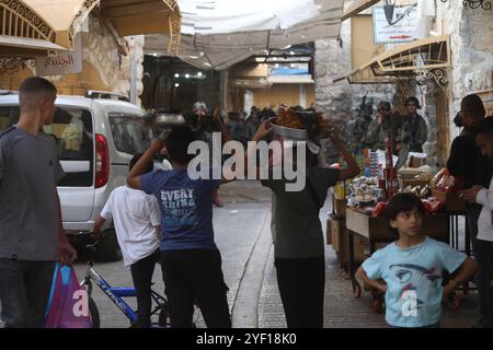 I coloni israeliani sono scortati da soldati israeliani durante un tour del mercato nella parte palestinese della città vecchia i coloni israeliani sono scortati da soldati israeliani durante un tour del mercato nella parte palestinese della città vecchia di Hebron nella Cisgiordania occupata il 2 novembre 2024. Foto di Mamoun Wazwaz apaimages Hebron Cisgiordania territorio palestinese 021124 Hebron MW 0032 Copyright: XapaimagesxMamounxWazwazxxapaimagesx Foto Stock