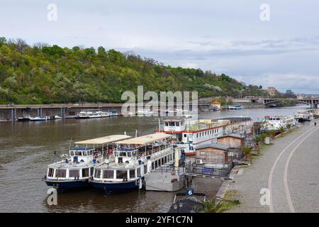 I turisti attraccano le barche sulle rive del fiume Moldava a Praga, capitale della Cechia (Repubblica Ceca) e storica capitale della Boemia. Foto Stock