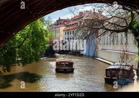 Taxi-boat sul pittoresco canale Čertovka (Canale del Diavolo), un corso d'acqua che separa Kampa da Mala strana nella città vecchia di Praga, Repubblica Ceca. Foto Stock