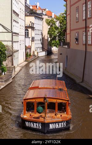 Taxi-boat sul pittoresco canale Čertovka (Canale del Diavolo), un corso d'acqua che separa Kampa da Mala strana nella città vecchia di Praga, Repubblica Ceca. Foto Stock