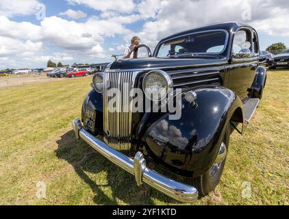 In una giornata di sole un pilota Ford V8 nero splendidamente presentato in un giorno aperto al Museo della Guerra fredda di Bentwaters a Rendlesham nel Suffolk Foto Stock