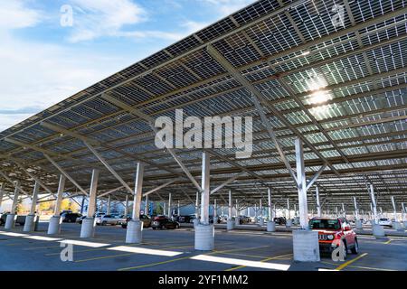 Calgary, Alberta Canada, ottobre 30 2024: Porta auto solare che genera energia pulita in una giornata di sole con auto parcheggiate all'ombra. Foto Stock