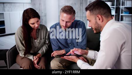 Felice Coppia Giovane a discutere con il consulente in ufficio Foto Stock