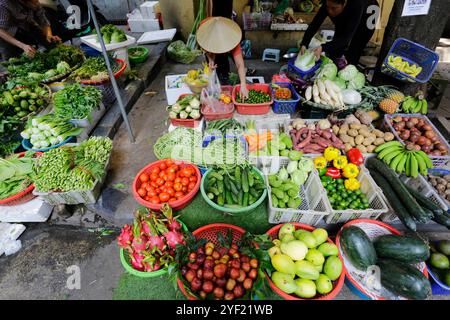 Hanoi, Vietnam - 14 luglio 2023: Venditori ambulanti vendono frutta e verdura in un mercato all'aperto nella capitale del Vietnam. Foto Stock