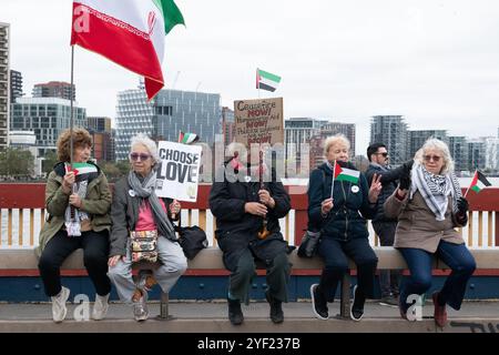 Londra, Regno Unito. 2 novembre 2024. Un gruppo di donne siede sul ponte Vauxhall mentre migliaia di sostenitori palestinesi organizzano la 22a marcia nazionale per la Palestina da quando Israele ha lanciato le guerre a Gaza, in Cisgiordania occupata e in Libano a seguito di un attacco da parte di militanti di Hamas. Organizzata dalla campagna di solidarietà della Palestina, Stop the War Coalition, Friends of al-Aqsa e The Muslim Association of Britain, la protesta si è radunata a Whitehall prima di marciare verso l'ambasciata degli Stati Uniti chiedendo un cessate il fuoco immediato, e la fine del supporto britannico e statunitense e delle vendite di armi a Israele. Crediti: Ron Fassbender/Alamy Live News Foto Stock