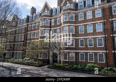 Case in mattoni rossi in via Hans Crescent nel Royal Borough di Kensington e Chelsea, Londra, Regno Unito. in primavera Foto Stock