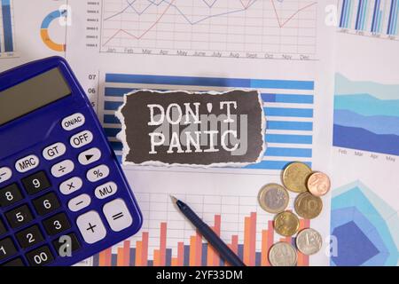 Mano che tiene in mano una nota di carta rosa con le parole Don't Panic. Foto Stock